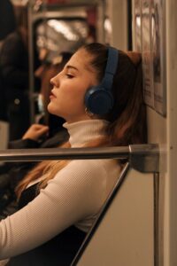 Подросток слушает музыку в метро